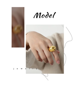Detailed view of a gold-plated geometric teardrop ring with a mirror-polished finish