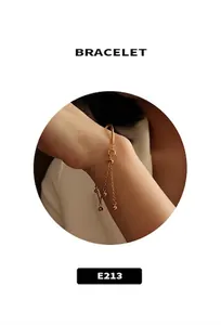 Gros plan d'un bracelet gourmette doré avec des breloques de perles rondes sur le poignet
