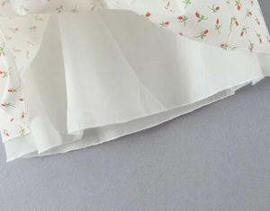 Detail view of floral print fabric with red flowers and white inner lining layers