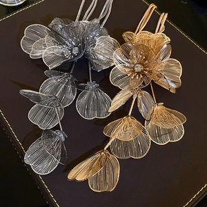 Detail of silver and gold metal flower pendants with mesh petals and crystal centers