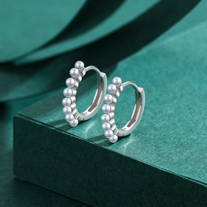 Elegant S925 sterling silver hoop earrings with eight lustrous white pearls on green background