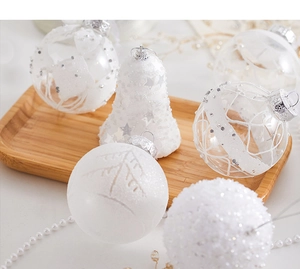 Close-up of white and clear Christmas tree ornaments in various textures on a wooden tray