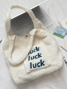 White faux shearling tote bag with blue luck letter embroidery and snap button closure