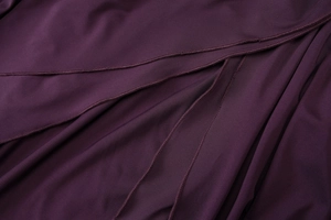 Macro shot of purple knit fabric texture and high-quality stitching on a strapless dress