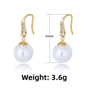Detail view of 24.6mm long pearl earrings with gold hooks and sparkling stones