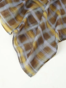 Close-up of mustard yellow and grey plaid textile with fine rolled hem stitching