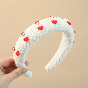Detail showing white knitted Christmas headband with mini Santa Claus plush ornaments