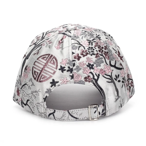 Macro shot of silver floral embroidery and adjustable metal buckle on a baseball cap