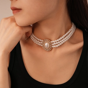 Close-up of triple-layer pearl choker with crystal-encrusted oval vintage clasp