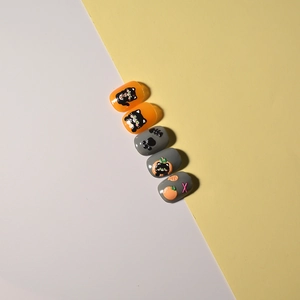 Close-up of black cat and fish 3D embossed nail art stickers with orange and grey accents