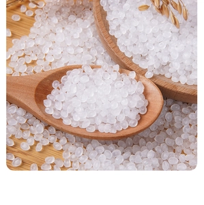 Close-up of translucent white simulation rice beads on a wooden spoon for DIY slime crafts