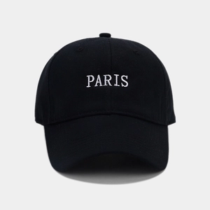 Detailed view of white PARIS embroidery on the front of a black cotton baseball cap