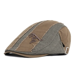 Detailed side view of canvas flat cap with letter A embroidery and metal buckle closure