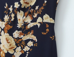 Detailed view of floral pattern print and waist stitching on navy blue slim dress