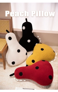 Close-up of four colorful pear plush pillows in textured fleece fabric on a beige rug