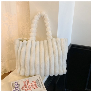 Close-up of white plush tote bag showing thick vertical stripes and soft faux fur texture