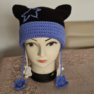 Detail of hand-knitted cat ear hat with purple star pendants and crochet texture