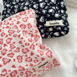 Detail of corduroy makeup bags featuring heart leopard prints and Sozakka woven label