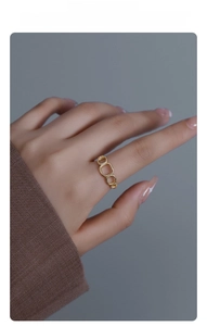 Detail of minimalist S925 silver gold-plated ring with three geometric rectangular links