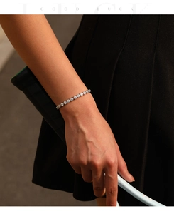 S925 zilveren moissanite tennisarmband om de pols met een tennisracket op de achtergrond