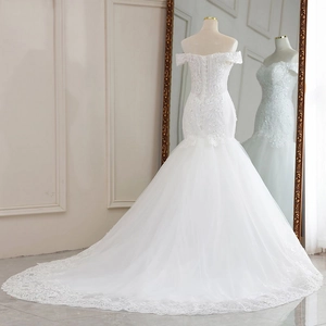 Detail of off-shoulder lace bodice with corset back and elegant mesh train on white gown