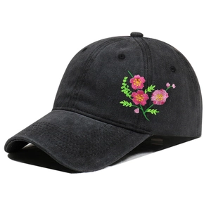Close-up of pink flower embroidery on a washed black cotton baseball cap for women