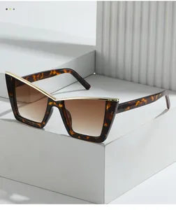Detail of cat eye sunglasses with tortoiseshell frames and gold metal accents
