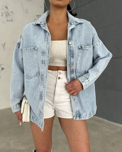 Detail of oversized light blue washed denim jacket with premium vintage finish