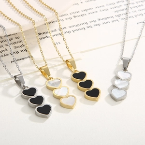 Flat lay of heart-shaped shell pendant necklaces in gold and silver steel finish