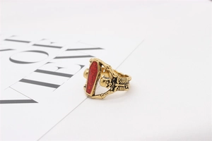 Macro view of gothic skull relief on antique gold coffin ring with red enamel inlay