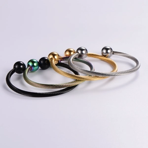 Detailed macro of four colored adjustable cable wire bangles with metal beads