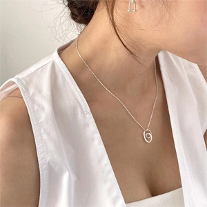 Close-up of elegant S925 sterling silver heart necklace and geometric earrings on model
