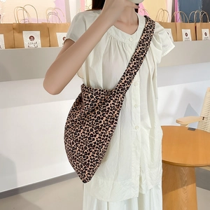 Detailed view of fashionable leopard print canvas crossbody bag with wide shoulder strap