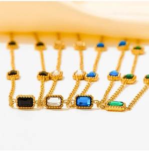 Detail showing gold stainless steel bracelets with black, clear, blue, and green zircon