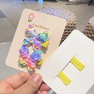 Detail of colorful sequined butterfly hair clips with pearls on a display card