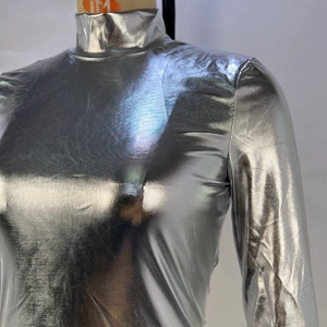 Détail du haut argenté métallique à manches longues avec col haut et texture réfléchissante