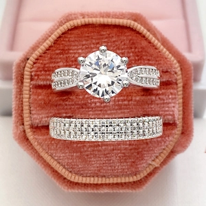 Macro detail of luxury wedding ring set with six-prong main diamond in velvet box