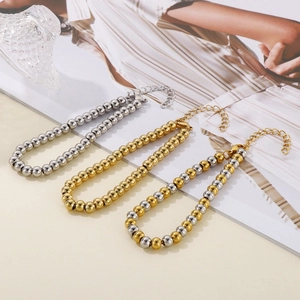 Détail de bracelets en perles d'acier inoxydable argenté et doré avec fermoirs mousqueton