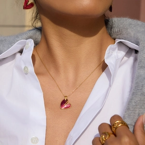 Vista dettagliata del set di gioielli a cuore in oro 18K con smalto rosso su modella