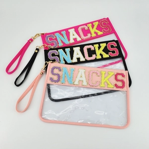 Detail of transparent PVC snack pouches with glitter SNACKS letters and wrist straps