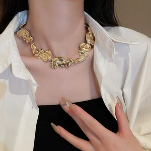 Detailed close-up of a gold geometric layered necklace worn on a model's neck