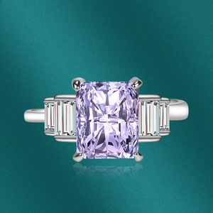 Detail showing radiant cut pink gemstone with side stones in a silver claw setting