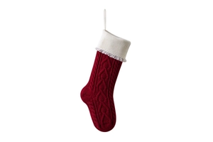 Detail of red knit Christmas stocking with heart pattern and white tassel ornament