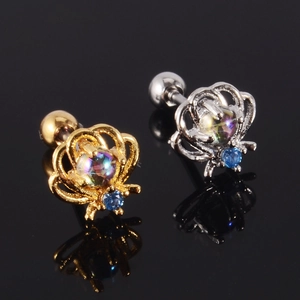 Detailed view of crown and spider stud earrings with aurora stones on reflective surface