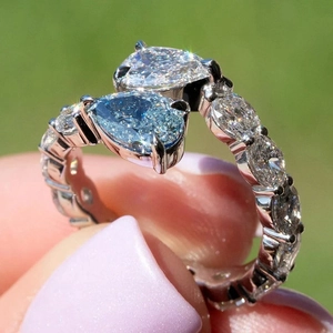 Luxurious Toi et Moi teardrop open ring with blue and white stones on a sparkling band
