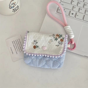 Detail of floral and blue striped cotton mini storage bag with pink heart button