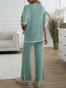 Back view of a green knit set featuring short sleeves and split hem casual trousers