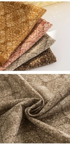 Detailed macro view showing the intricate paisley pattern and texture of the silk scarf
