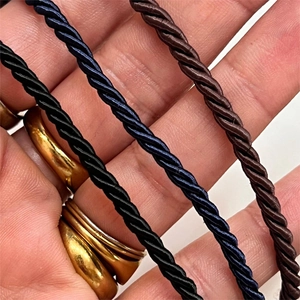 Dettaglio di catene in corda intrecciata multicolore in nero, blu scuro e marrone