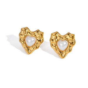 Detail of gold heart earrings with lava texture and central pearl on white background